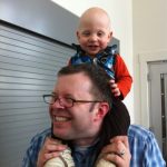 Sam the Anti-Preemie sitting on dad's shoulders